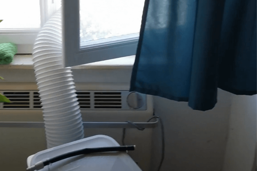 Der Abluftschlauch wird aus dem Fenster gehängt